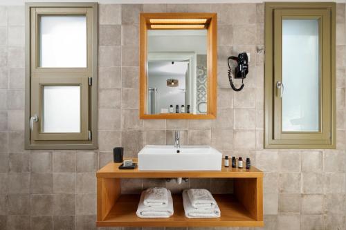 a bathroom with a sink and a mirror at Callisto Seaside Homes & Suites in Marathopolis