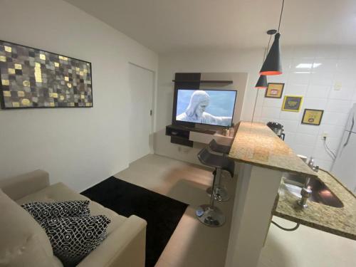 Una sala de estar con un sofá y un televisor. en Apartamento charmoso no Rio, en Río de Janeiro