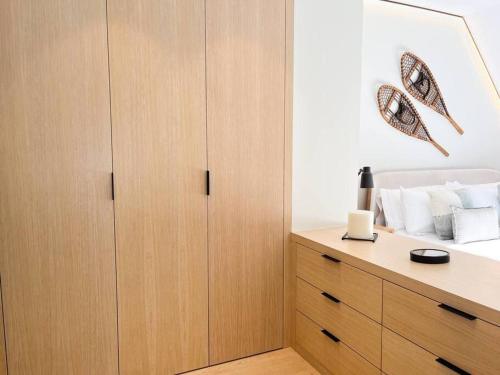 a bedroom with a bed with wooden cabinets at Ático Dúplex De Lujo - CLASIFICACIÓN 5 ESTRELLAS - 8PAX - A Pie Del Centro - 2 PARKINGS l by BonesVacances in Andorra la Vella