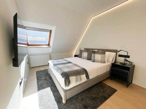 a bedroom with a large bed and a window at Ático Dúplex De Lujo - CLASIFICACIÓN 5 ESTRELLAS - 8PAX - A Pie Del Centro - 2 PARKINGS l by BonesVacances in Andorra la Vella