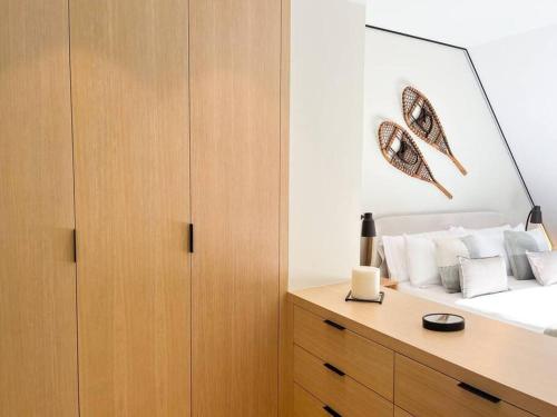 a bedroom with a bed with a wooden cabinet at Ático Dúplex De Lujo - CLASIFICACIÓN 5 ESTRELLAS - 8PAX - A Pie Del Centro - 2 PARKINGS l by BonesVacances in Andorra la Vella