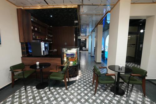 een restaurant met 2 tafels en groene stoelen bij Taksim Bosphorus Hotel in Istanbul
