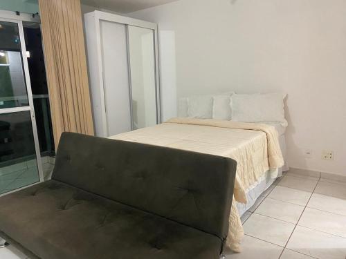 a bedroom with a bed with a couch in it at Apto Green Park Águas Claras apto 1526 in Águas Claras