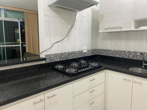 a kitchen with a stove and a counter top at Apto Green Park Águas Claras apto 1526 in Águas Claras