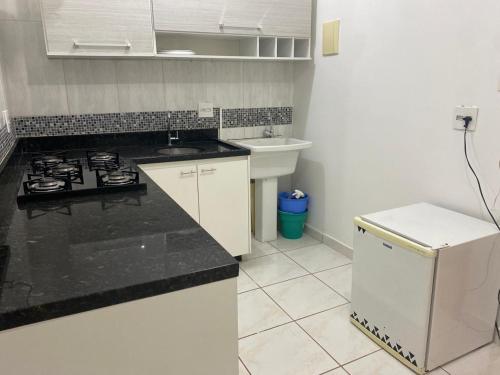 a kitchen with a stove and a sink at Apto Green Park Águas Claras apto 1526 in Águas Claras
