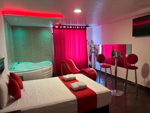 a bedroom with a tub and a bed with red chairs at GOLDEN DREAM´S in Lima