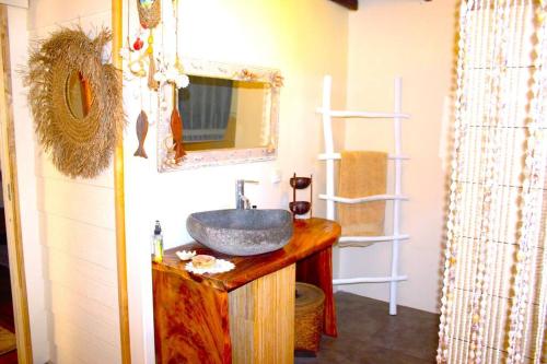 a bathroom with a sink and a mirror at Villa Ruma Maria in Uturoa