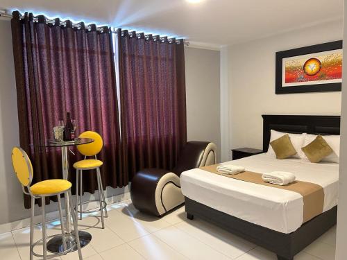 a bedroom with a bed and two chairs and a table at GOLDEN DREAM´S in Lima