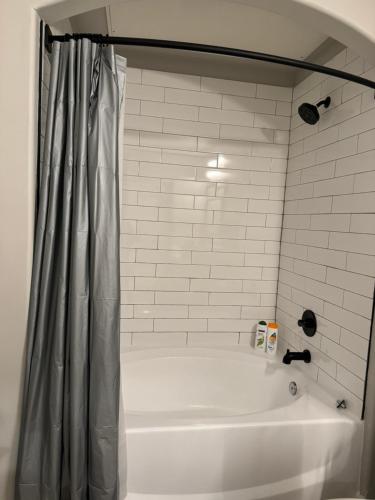 a white bath tub with a shower curtain in a bathroom at Towson Elite Apartment in Towson