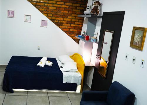 阿雷格里港的住宿－APARTAMENTO com SUITE DE CINEMA Prox Bourbon Ipiranga，一间卧室配有一张床和一张蓝色椅子
