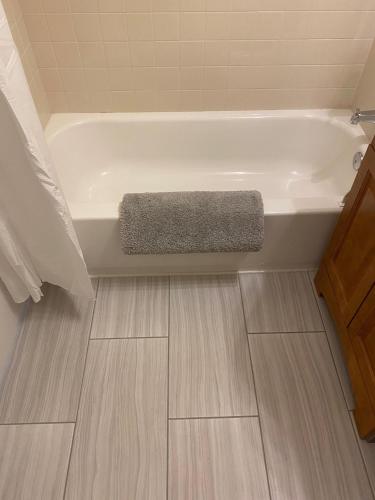 a bathroom with a bath tub and a wooden floor at The Irish Inn in Hood River