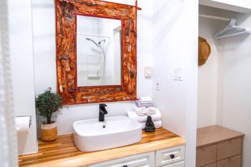 a bathroom with a white sink and a mirror at Oasis Top Floor Suite with Lake and Mtn View in Harrison Hot Springs