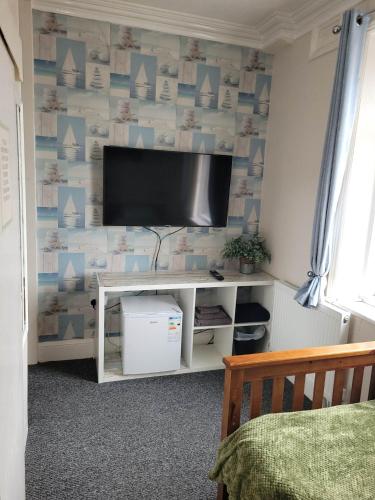 a living room with a tv on a wall at Maydene Hotel in Blackpool