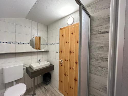 baño con lavabo y puerta de madera en Hotel Gasthof Seeblick en Zeutschach