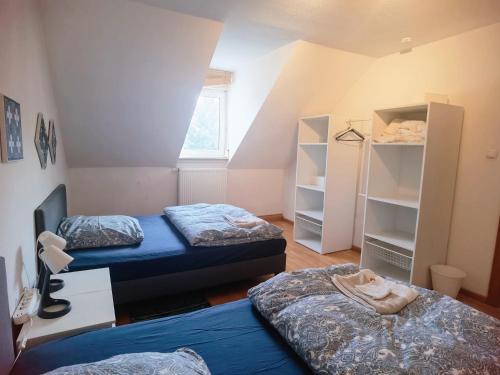 Zimmer mit 2 Betten und Regalen in der Unterkunft Bad Homburg Wohnung für 5 Personen in Bad Homburg vor der Höhe
