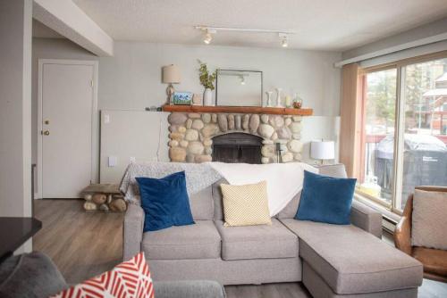 a living room with a couch and a fireplace at Moguls, Lofted Ski in Ski Out with Hot Tub Access in Panorama