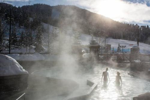 a group of people standing in a hot tub in a geyser at Moguls, Lofted Ski in Ski Out with Hot Tub Access in Panorama