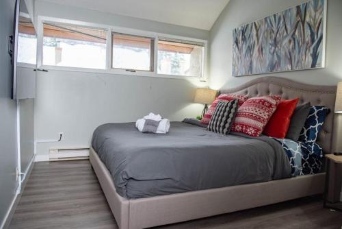 a bedroom with a large bed with red pillows at Moguls, Lofted Ski in Ski Out with Hot Tub Access in Panorama