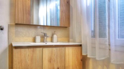 a bathroom with a sink and a mirror and a window at Sofi-Art House in Kynopiástai