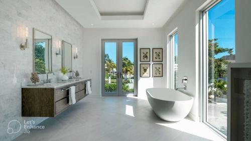 La salle de bains est pourvue d'une baignoire et d'une grande fenêtre. dans l'établissement New Luxury Waterfront Condo, Palm Cay, The Bahamas, à Nassau