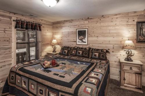a bedroom with a large bed in a room with wooden walls at Canyon Cabins in Ruidoso
