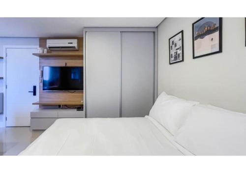 1 dormitorio con 1 cama blanca y TV en Charlie The Park Cidade Baixa, en Porto Alegre