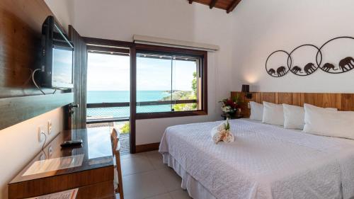 HOTEL VILLE LA PLAGE & BEACH CLUB في بوزيوس: غرفة نوم مع سرير وإطلالة على المحيط