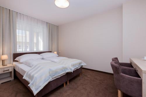 a bedroom with a bed and a desk and a window at Apartamenty Angela in Pobierowo