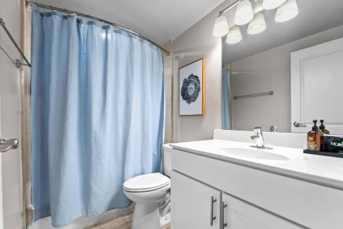 łazienka z niebieską zasłoną prysznicową i toaletą w obiekcie Peaceful DC Getaway Near Metro w mieście Arlington