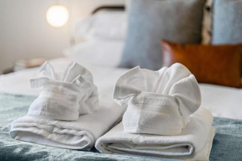two white towels sitting on top of a bed at Chic DC Getaway Near Metro in Arlington