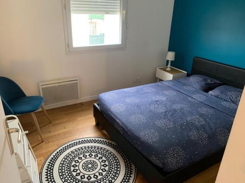 Un dormitorio con una cama azul y una ventana en IMPRIMERIE en Saint-Denis