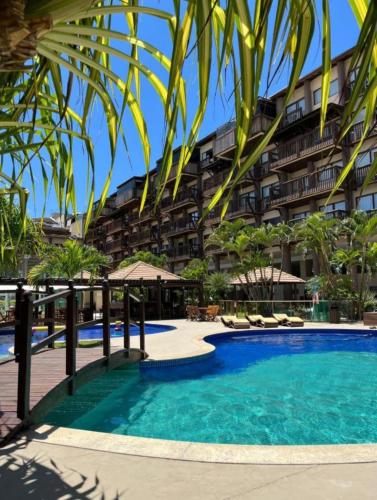 una piscina frente a un gran edificio en Apartamento em Barra Bali, Resort de Luxo, Barra de São de Miguel - 223, en Barra de São Miguel