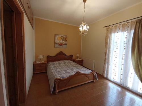 Schlafzimmer mit einem Bett und einem Fenster mit einem Kronleuchter in der Unterkunft Kantouni Bedroom in Faraklata