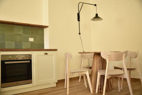 uma cozinha com uma mesa e cadeiras e um candeeiro em Sky and Vineyards - Nespolo - em La Morra