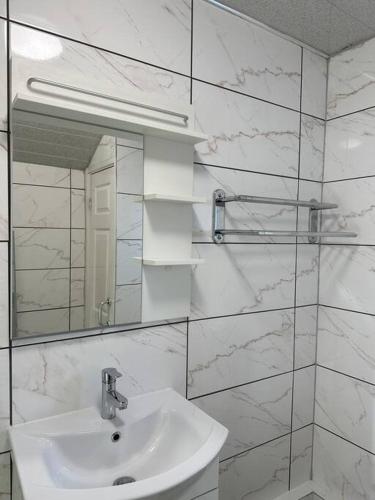 Baño blanco con lavabo y espejo en Modern 1 Bed Flat In Derby City, en Derby