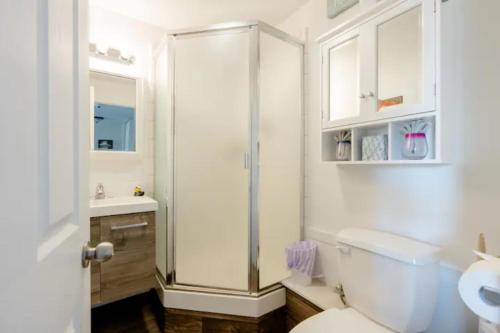 a white bathroom with a shower and a toilet at The Irish Inn in Hood River