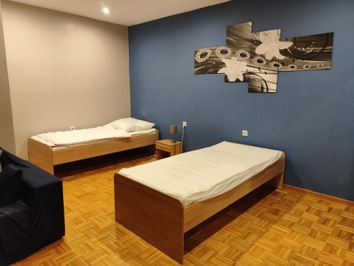 1 dormitorio con 2 camas y pared azul en Ferienwohnung Belvie, en Butzbach