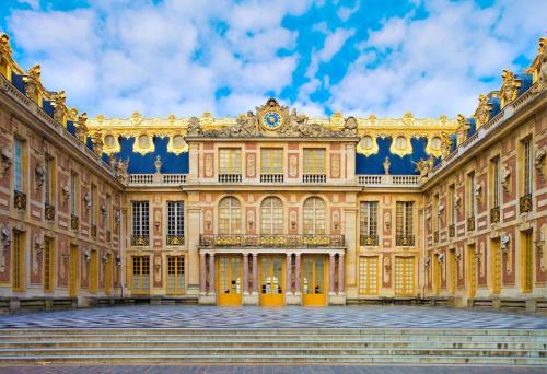 Un gran edificio con un reloj en el costado. en Studette Rémilly à Versailles, en Versalles