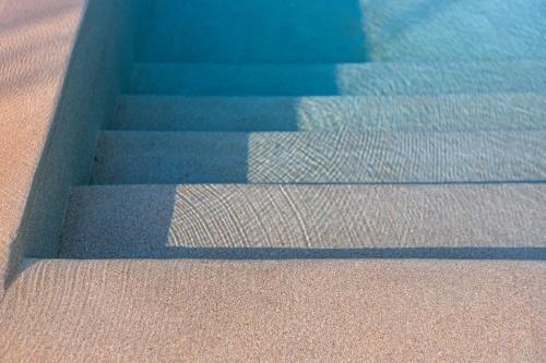 a set of stairs next to a swimming pool at Callisto Seaside Homes & Suites in Marathopolis