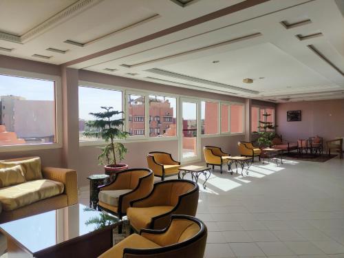 a large room with chairs and tables and windows at Hotel Idou Tiznit in Tiznit