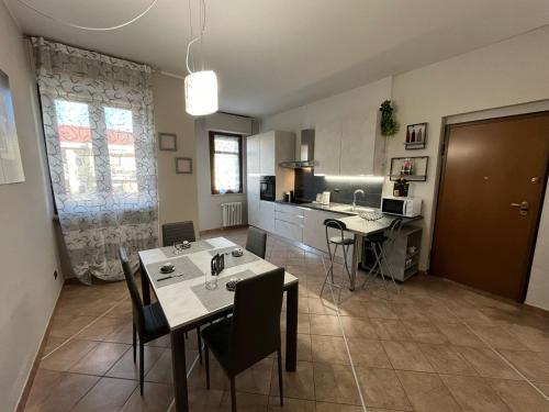 a kitchen with a table and chairs in a room at L'ORCHIDHEA APARTMENT in Savigliano
