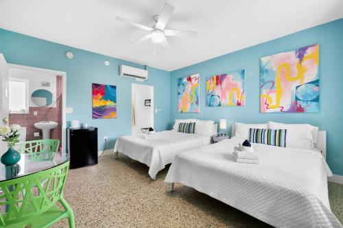 2 Betten in einem Zimmer mit blauen Wänden in der Unterkunft The New Yorker Miami Hotel in Miami