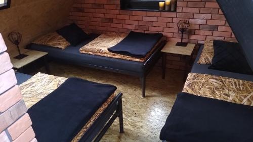 a room with three beds and a brick wall at Zaciszny Zakątek Zawoja in Zawoja