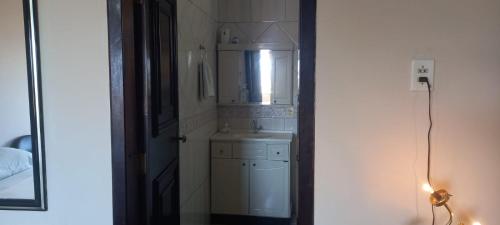 a small bathroom with a sink and a mirror at Estúdio central PG1 prox Paladium in Ponta Grossa