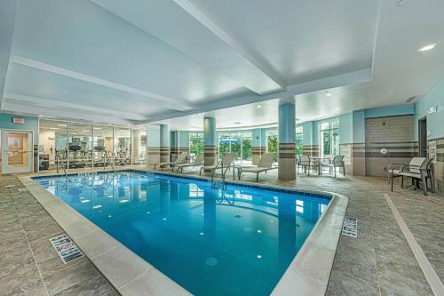 a large swimming pool in a hotel lobby at Holiday Inn Express & Suites Charleston Arpt-Conv Ctr Area by IHG in Charleston