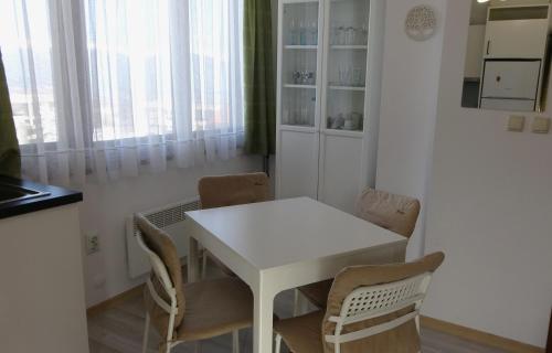a white dining room with a white table and chairs at Mountainview Apartment Ski, Spa & Thermal in Bansko