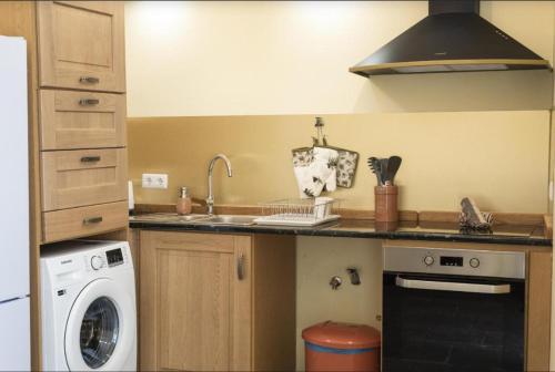 a kitchen with a sink and a washing machine at Grand studio 29 in Faro