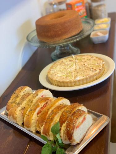 - une table avec deux assiettes de pain et un gâteau dans l'établissement Pousada do Nica, à Fernando de Noronha