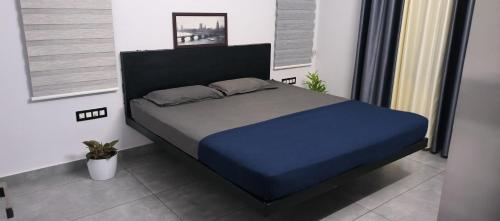 uma cama num quarto com uma colcha azul em UnnisHome em Adūr