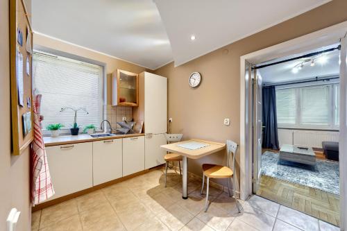 kuchnia z biurkiem, stołem i oknem w obiekcie Apartament Kapelanka CoWork w Krakowie